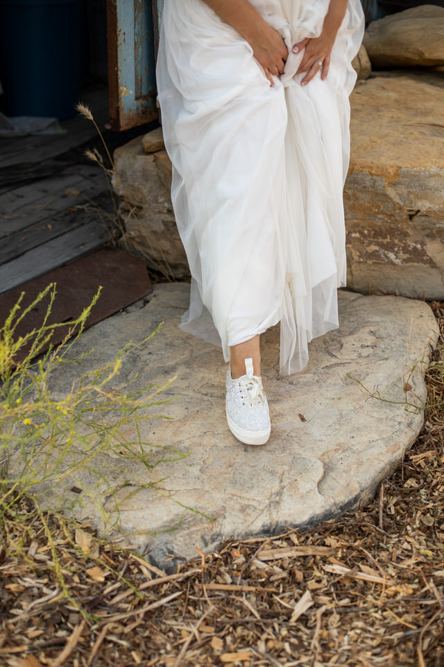 a bride wearing white glittered Ked tennis shoes