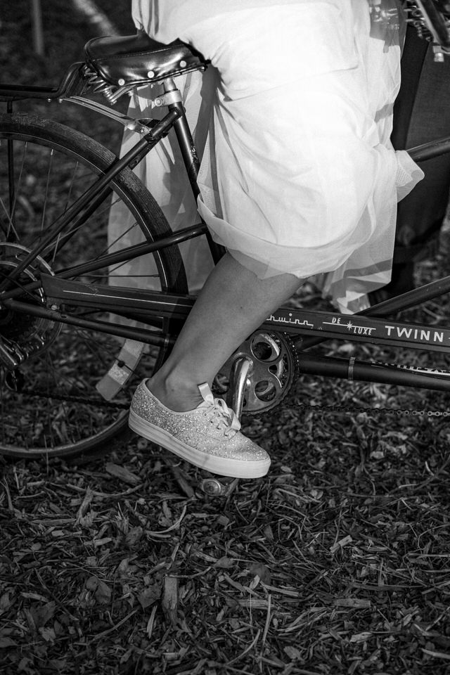 a bride wearing white glittered Ked tennis shoes on a Schwinn Bike