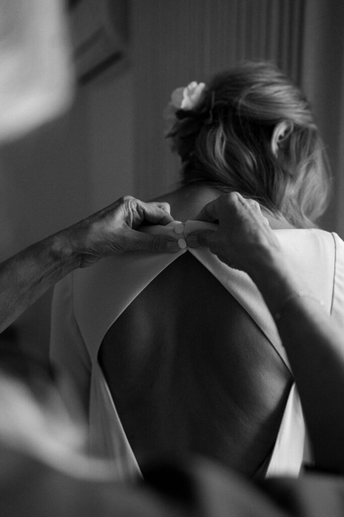 Bride getting ready in sunlit suite at The Pearl Hotel with mid-century decor and soft natural light.