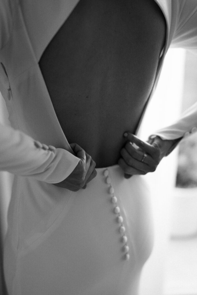 Bride getting ready in sunlit suite at The Pearl Hotel with mid-century decor and soft natural light.