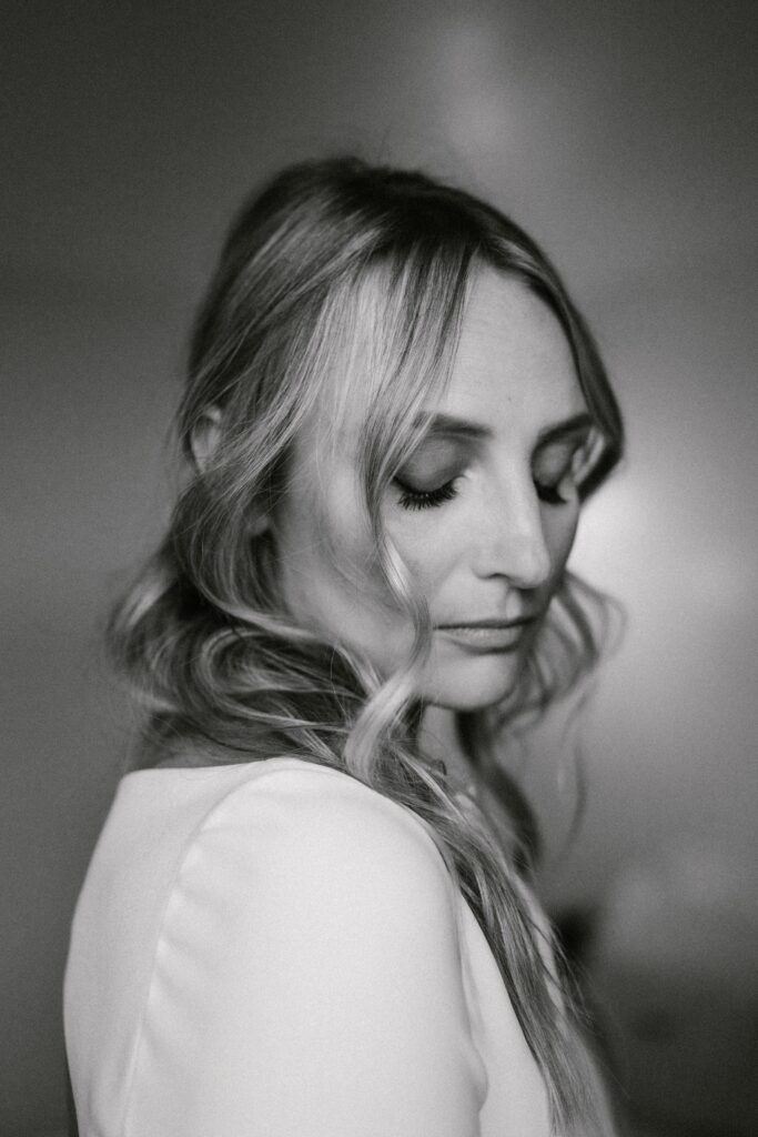 Bride getting ready in sunlit suite at The Pearl Hotel with mid-century decor and soft natural light.