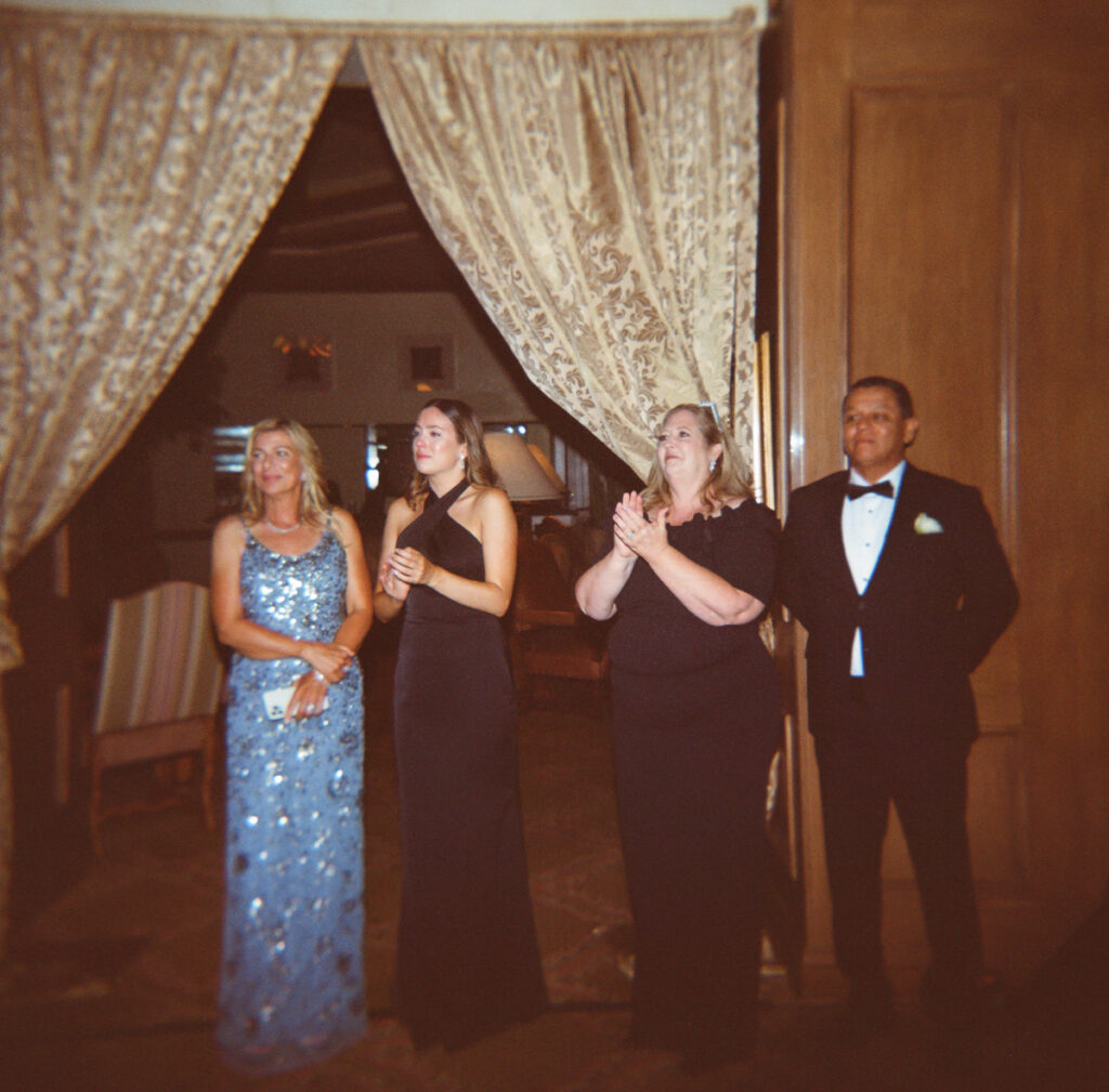 Family and wedding party gathered near reception entrance at Del Mar Country Club.