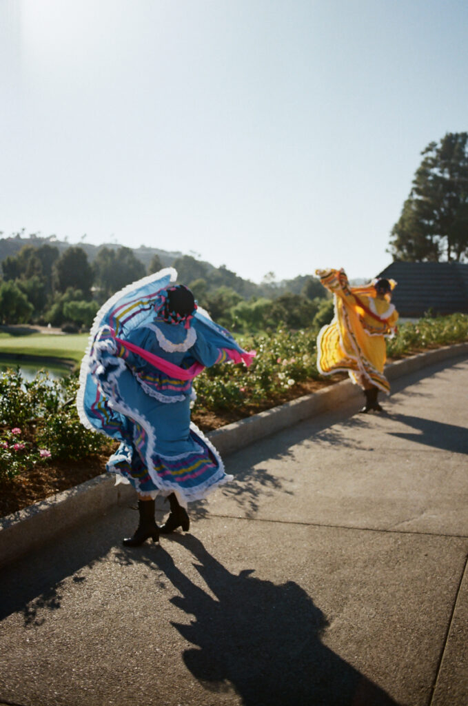 Folklórico dancers in blue and yellow dresses performing at Del Mar Country Club.