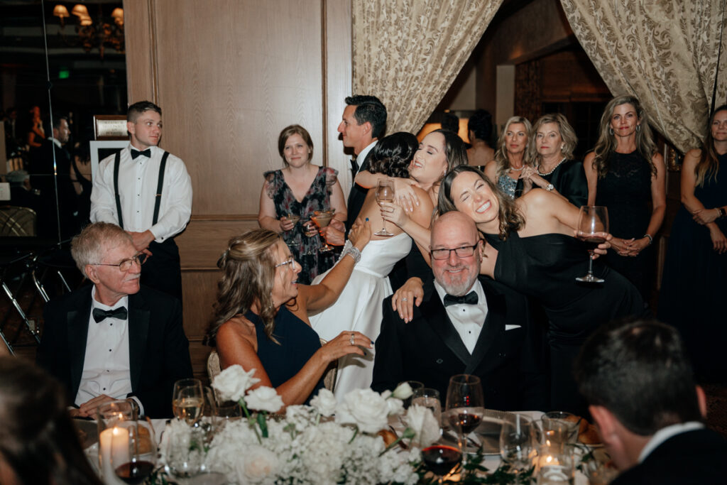 Guests laughing and cheering during toasts at Del Mar Country Club reception.