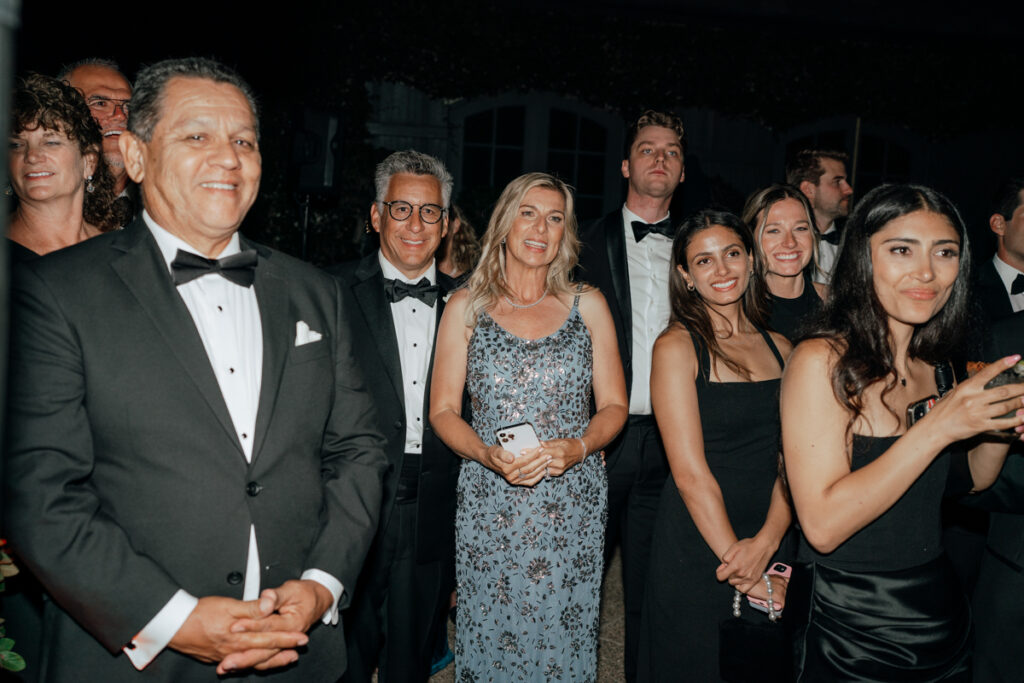 Guests smiling and watching entertainment during Del Mar Country Club wedding reception.