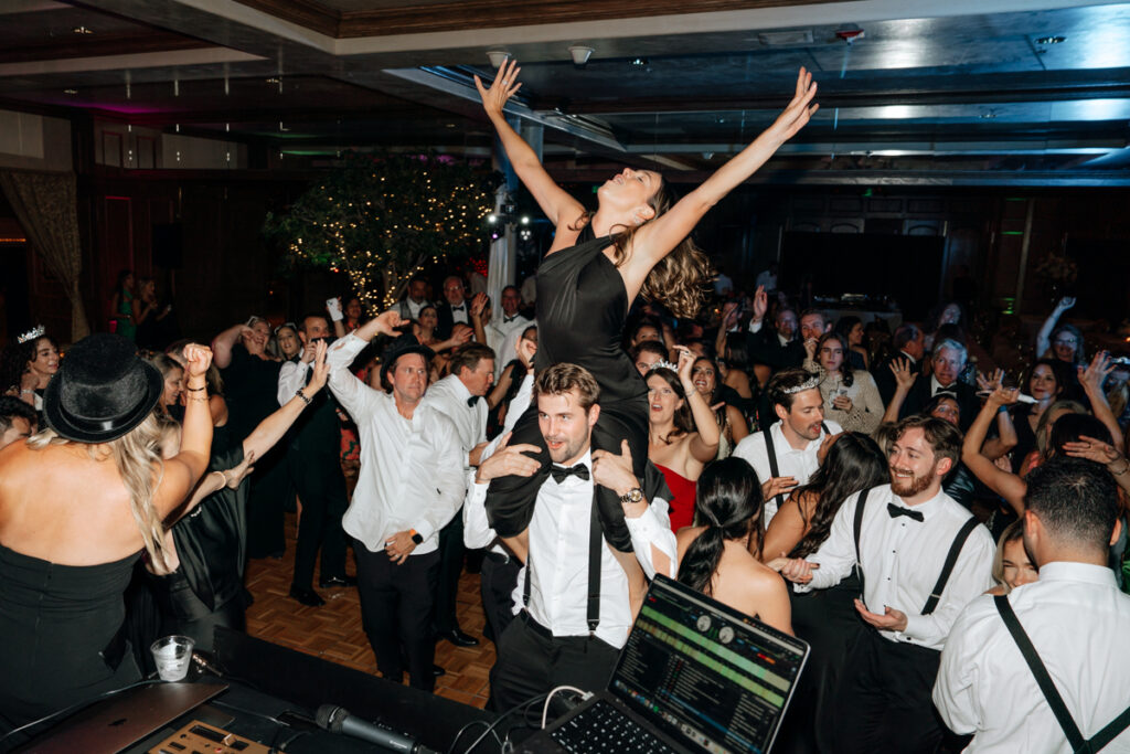 Bridesmaid lifted above the crowd on dance floor at Del Mar Country Club.