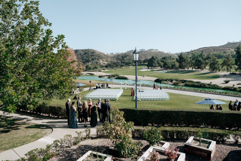 Guests gathering on the lawn with golf course views at Del Mar Country Club wedding.