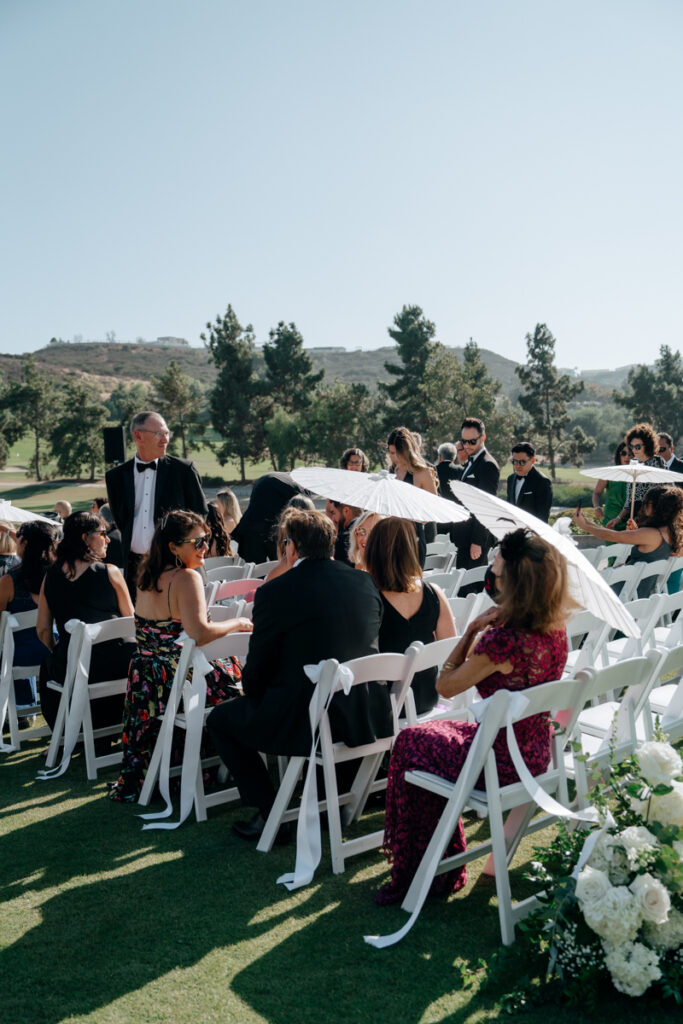 Guests taking their seats at outdoor ceremony at Del Mar Country Club.