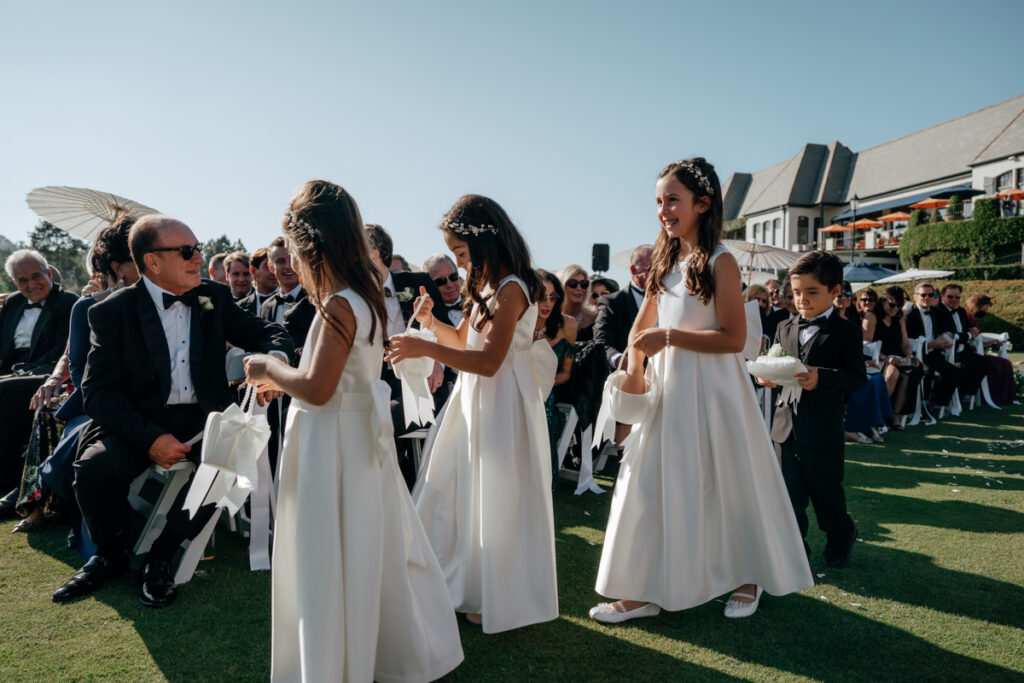 Flower girls walking down the aisle with baskets at outdoor ceremony, Del Mar Country Club.