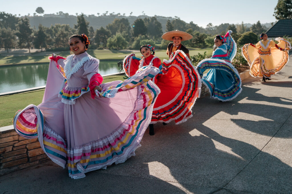 Folklórico dancer twirling in pink dress during wedding celebration at Del Mar Country Club.