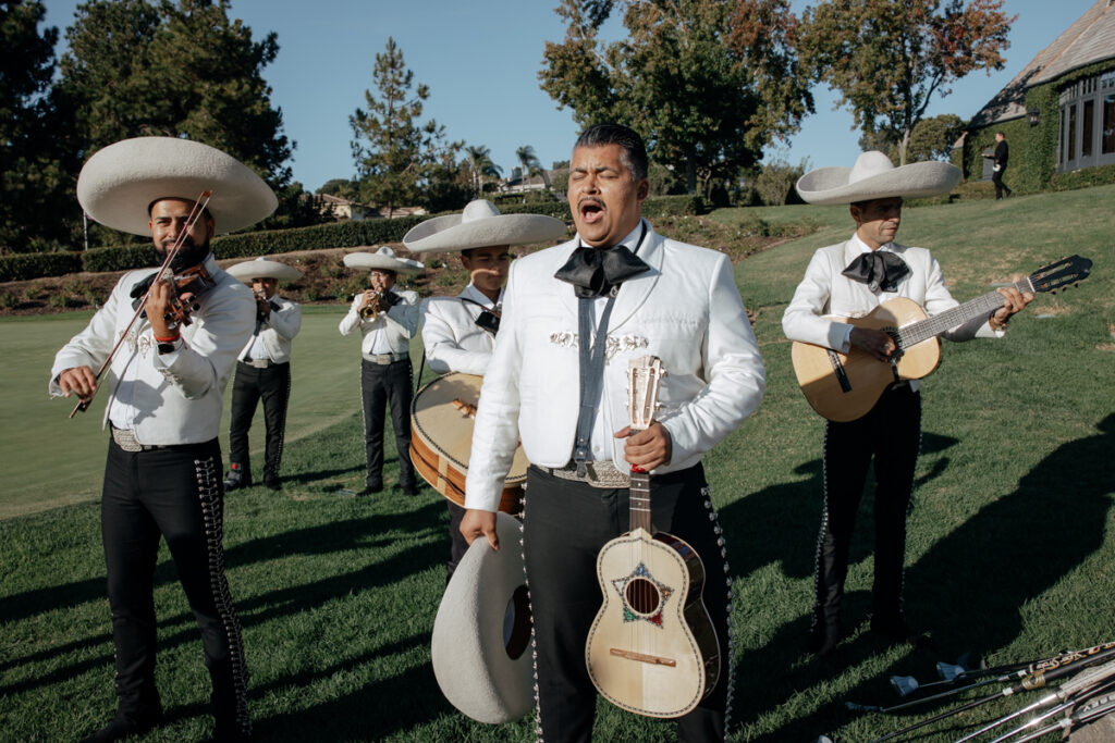 Close-up of mariachi musicians singing and playing guitar at Del Mar Country Club wedding.