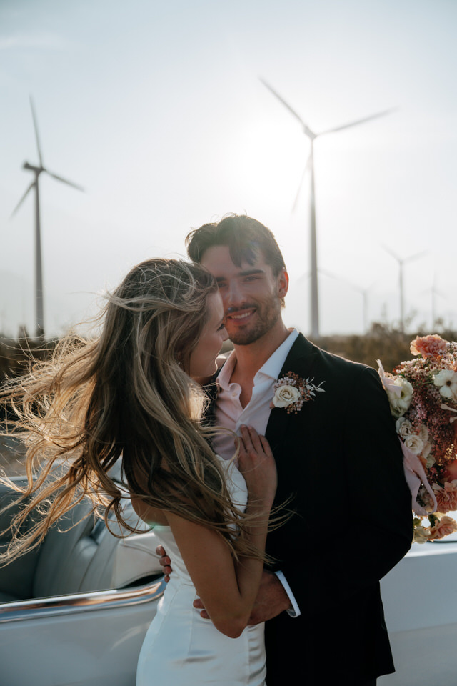 Bride smiling at groom during candid wedding portraits at Palm Springs windmills