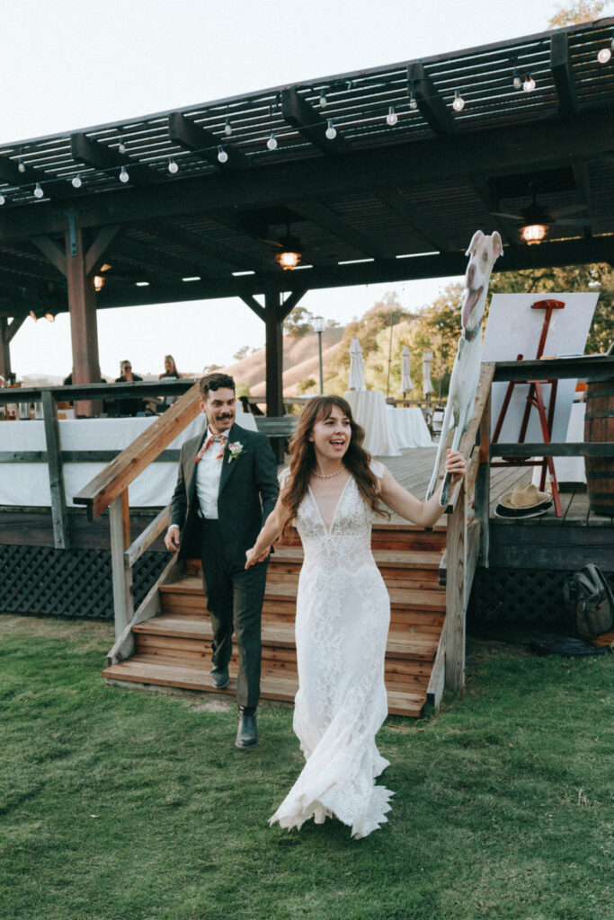 Bride and groom walking down the steps into the reception under string lights