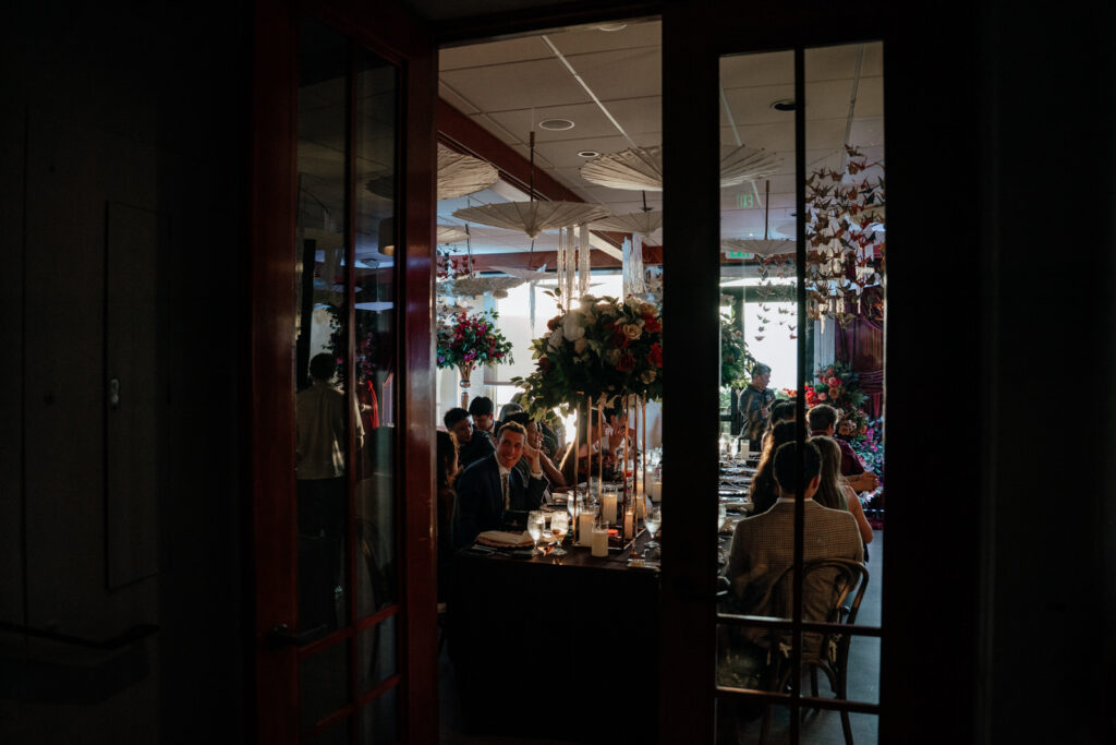 Mirrored doors reflecting the reception room's florals and hanging decor
