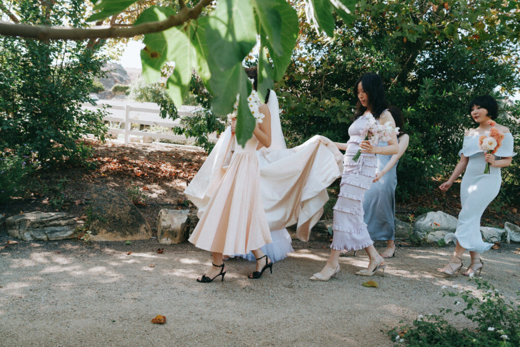 Bridesmaids walking together under the trees before the ceremony