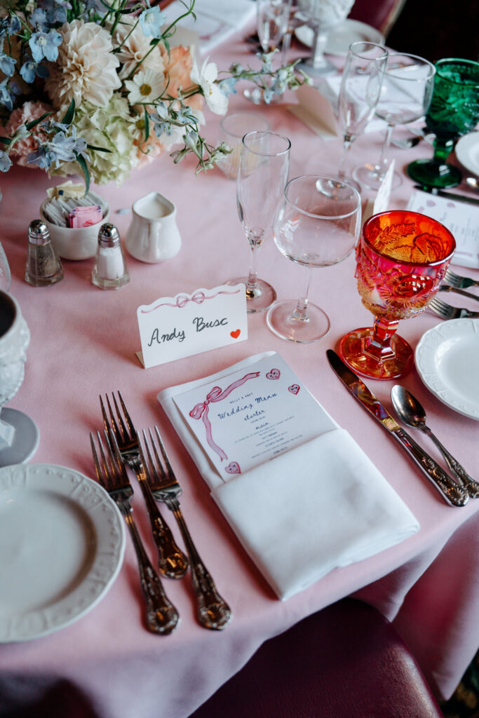 Table setting with vintage colored glassware and a hand-lettered place card
