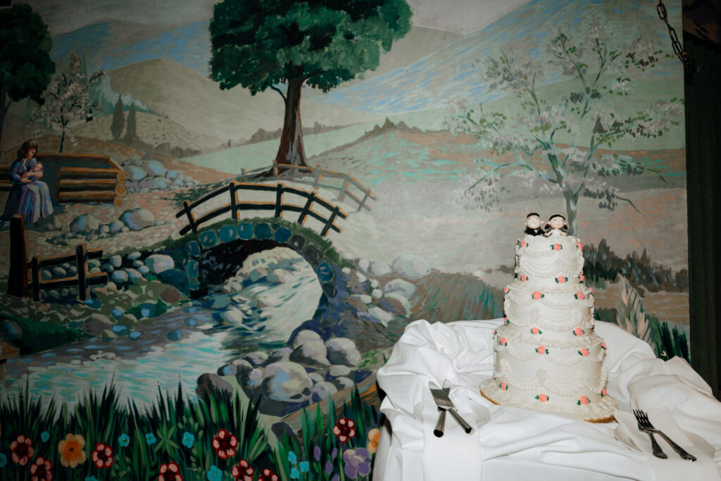 Hand-painted mural behind the wedding cake at the reception